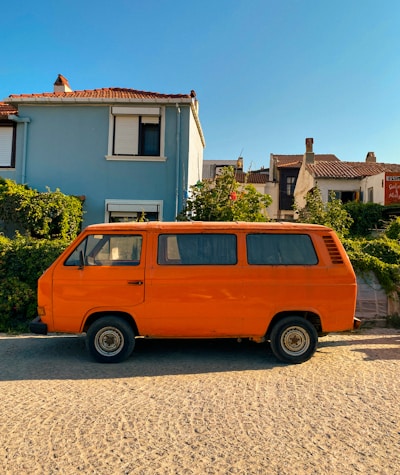 A bright removal van parked outside a cozy Birmingham home on a sunny day.