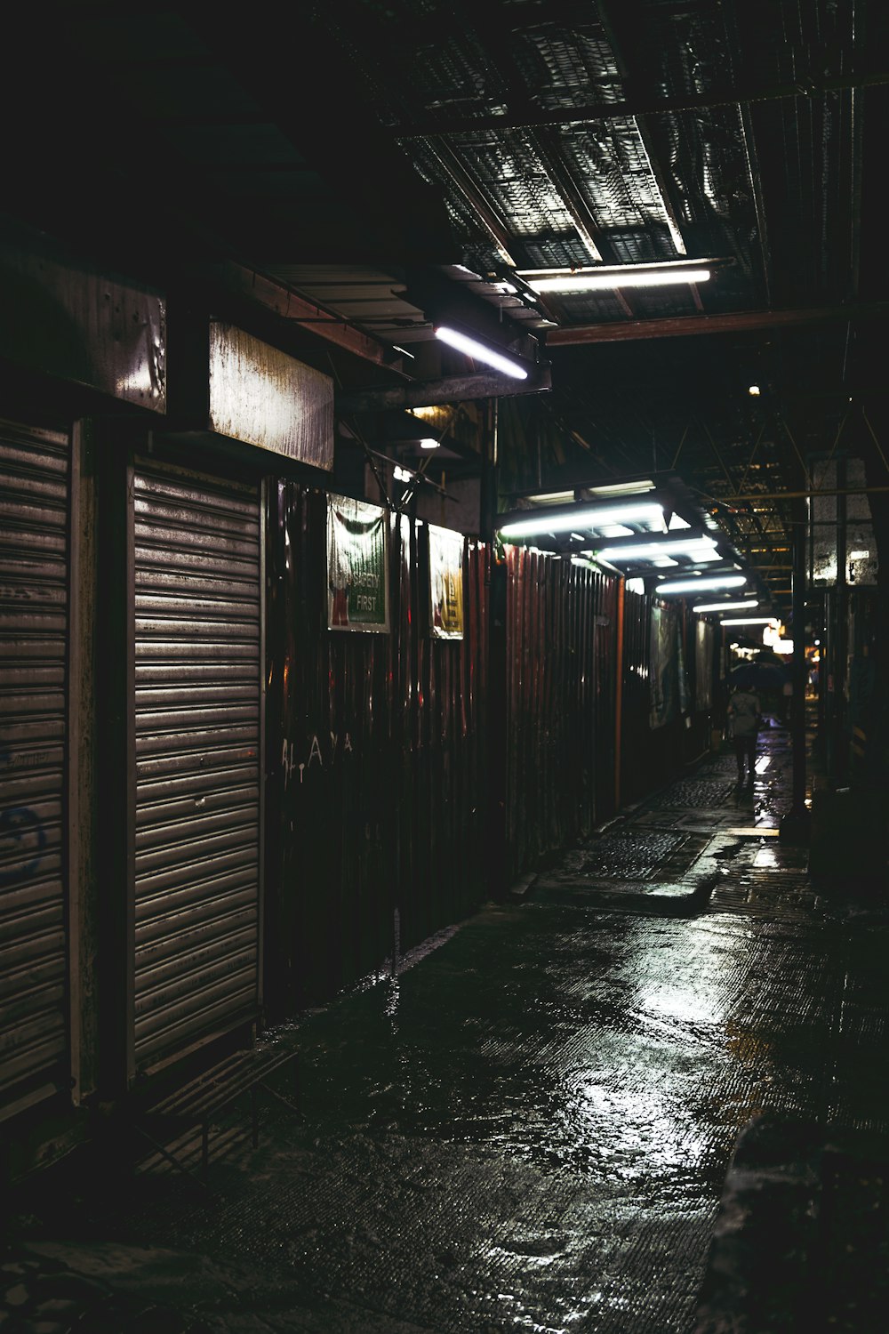 un callejón mojado con una persona caminando