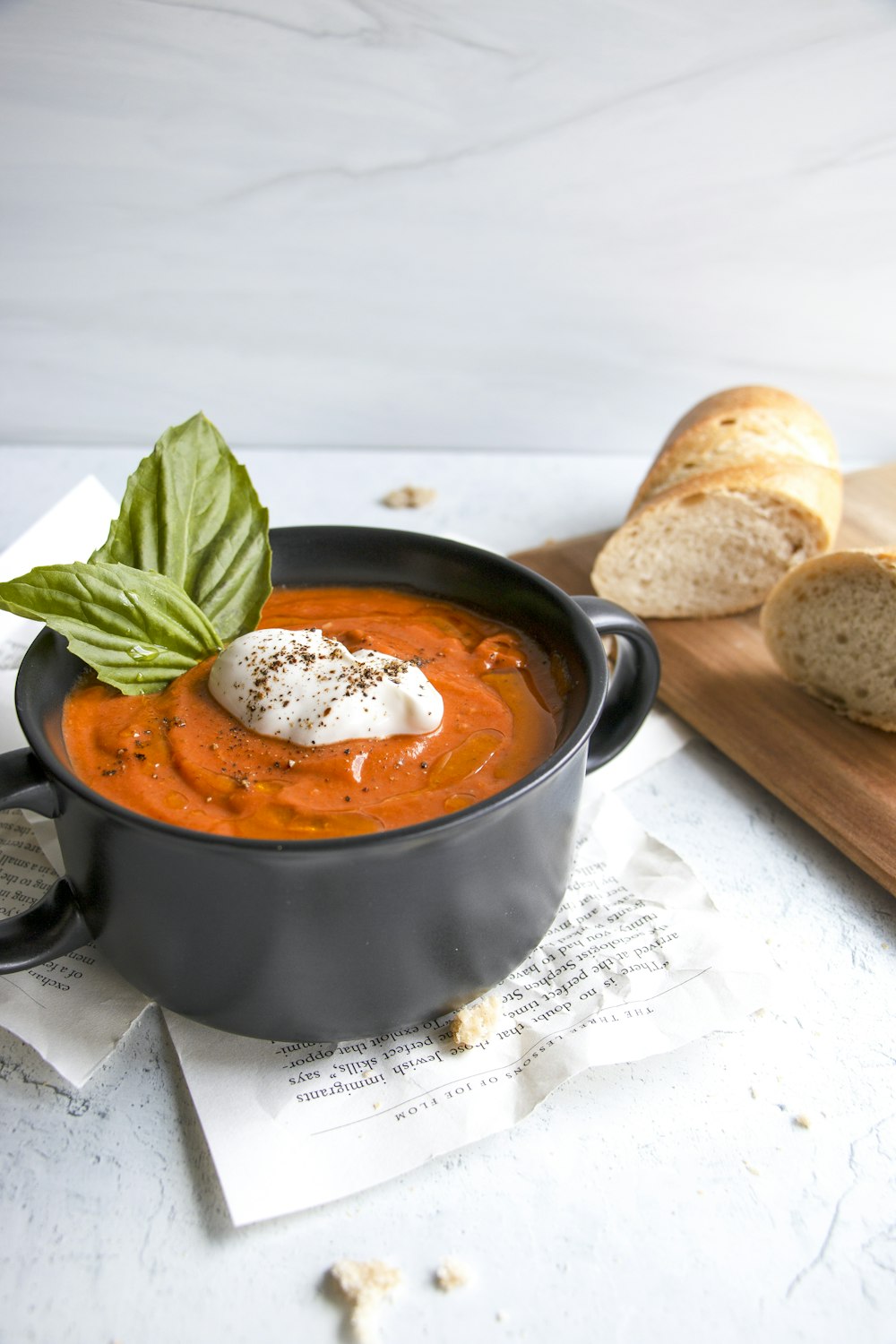 a pot of soup with bread and a leaf on a stove