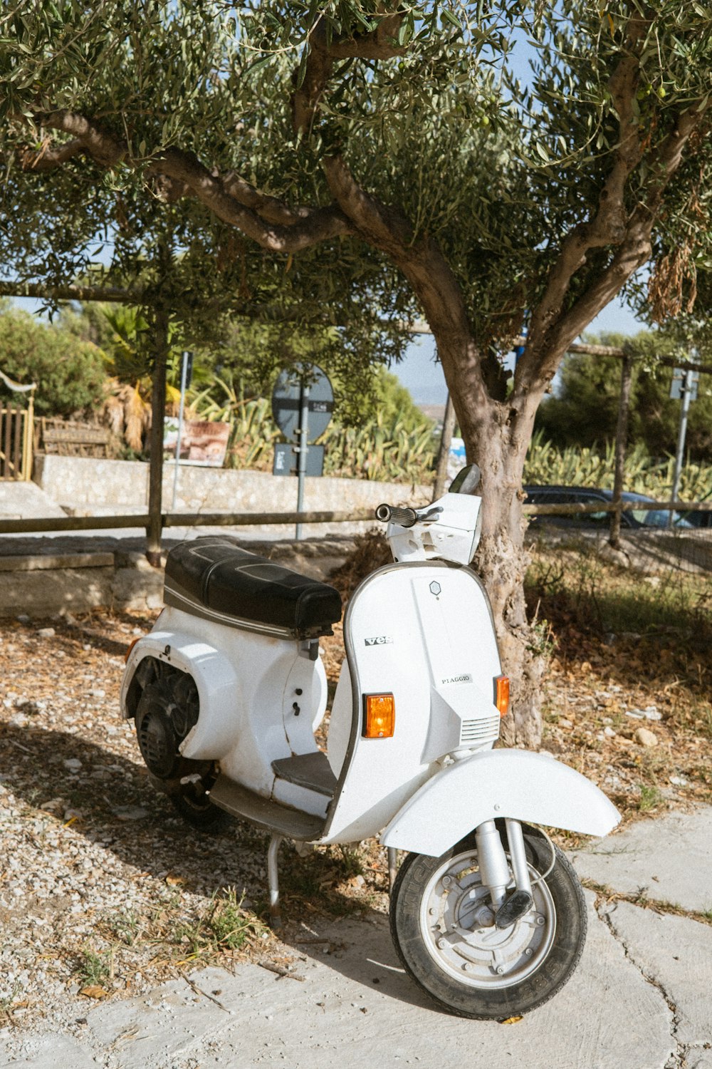 a white scooter parked on the side of a road