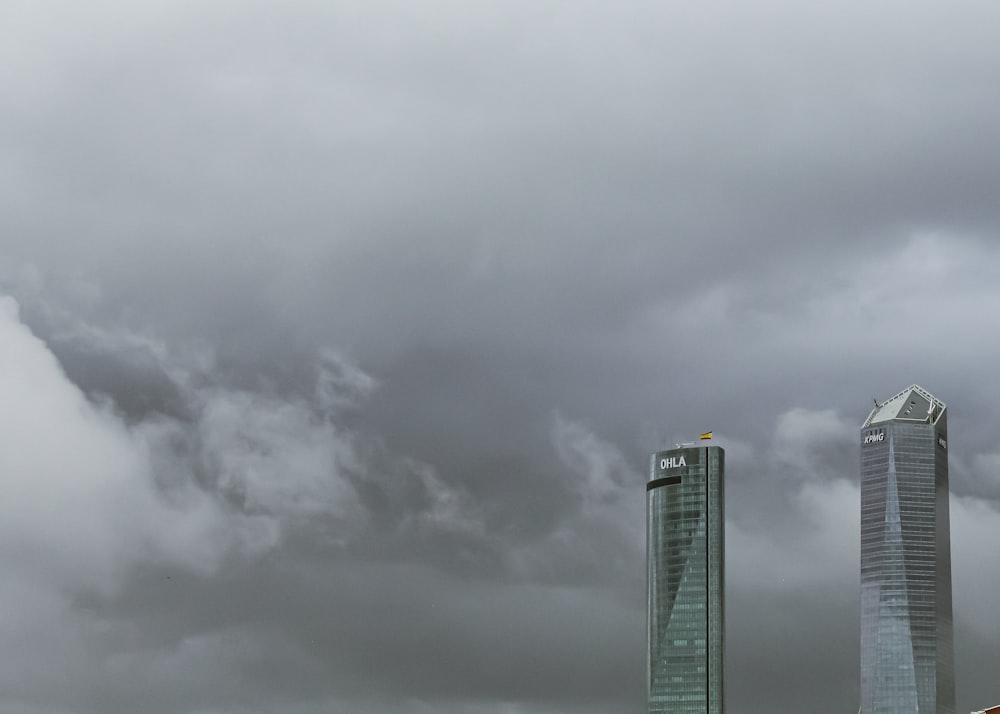 two tall buildings with clouds in the background