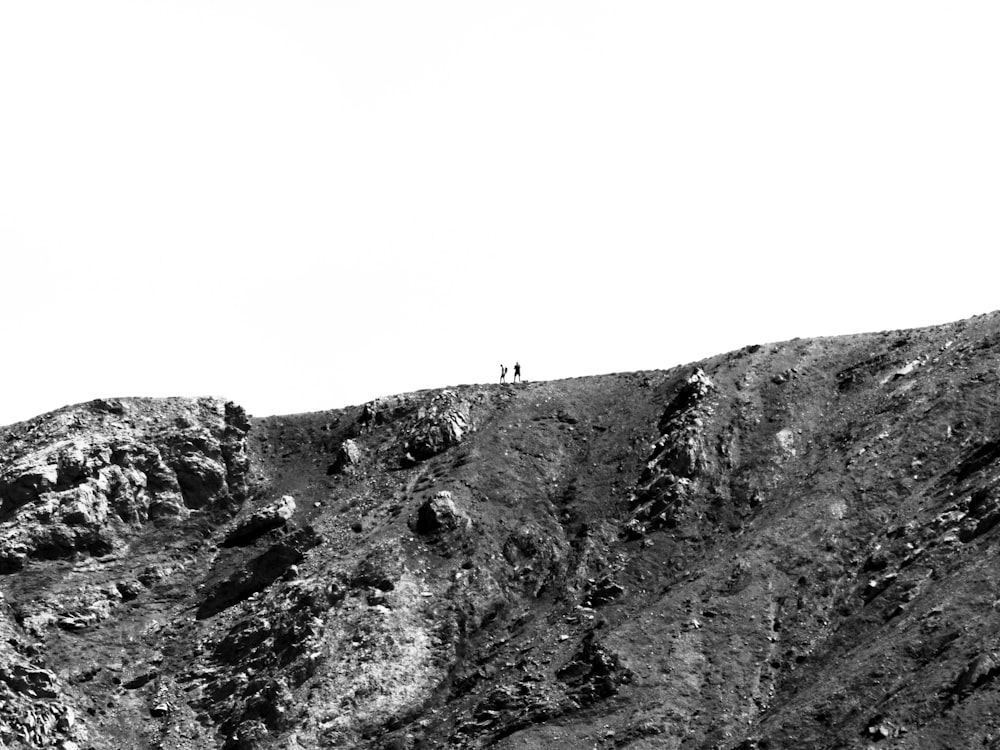 a couple people walking up a mountain