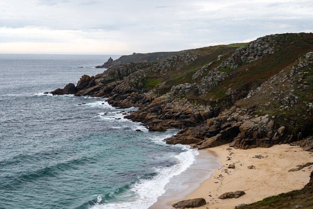 a rocky beach with a large body of water in the background