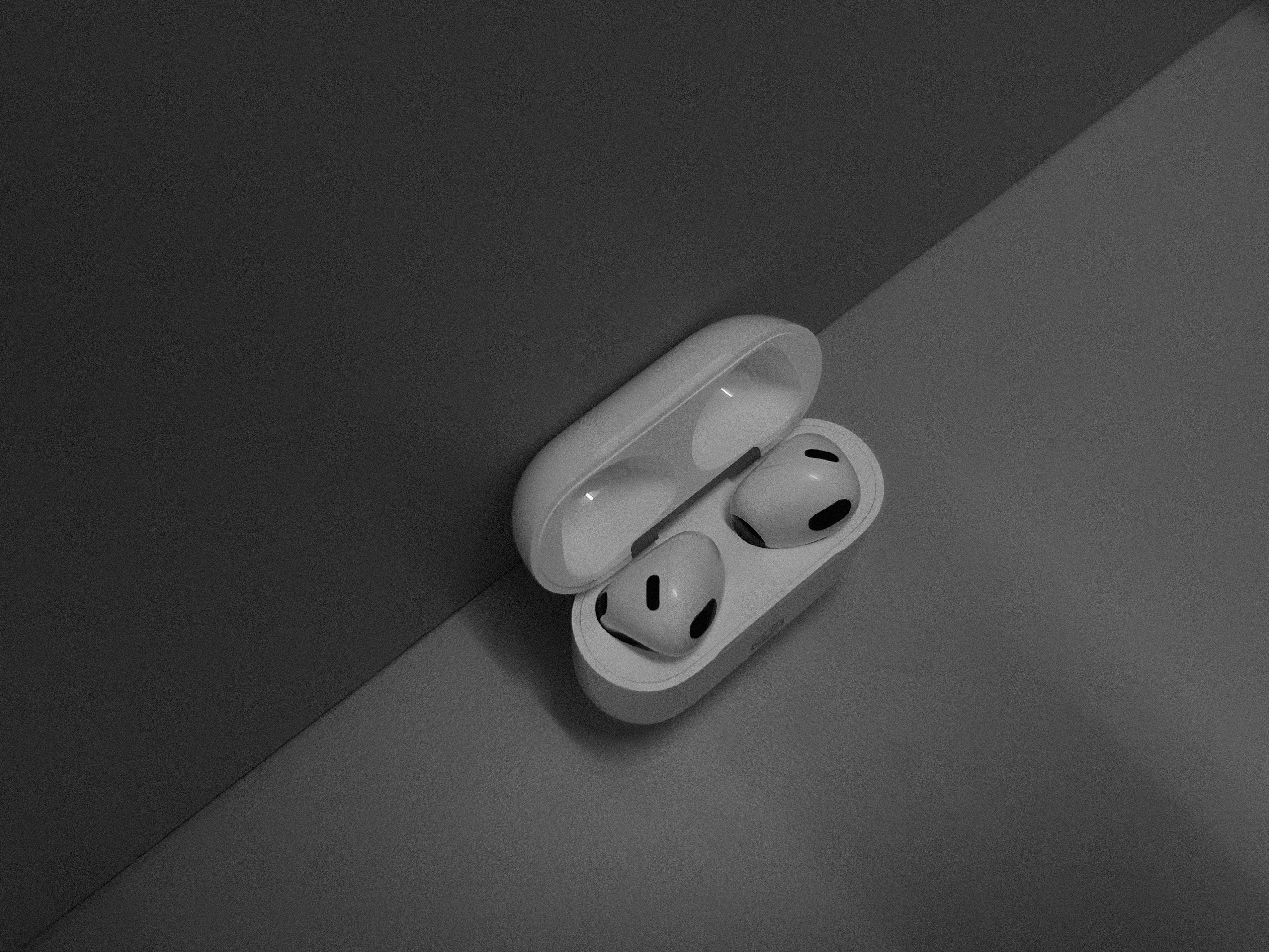 White wireless earbuds in charging case on dark background
