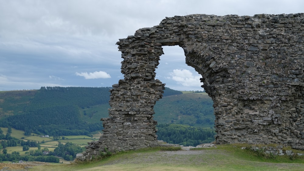 a stone wall with a valley below