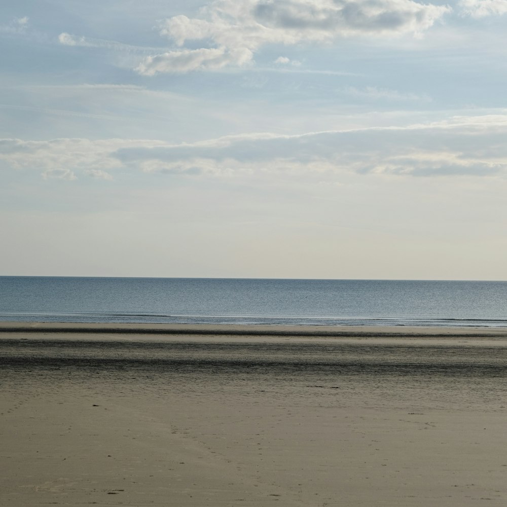 a beach with a body of water in the background