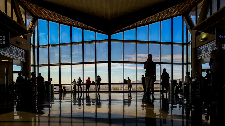 People in a large hall with tall windows