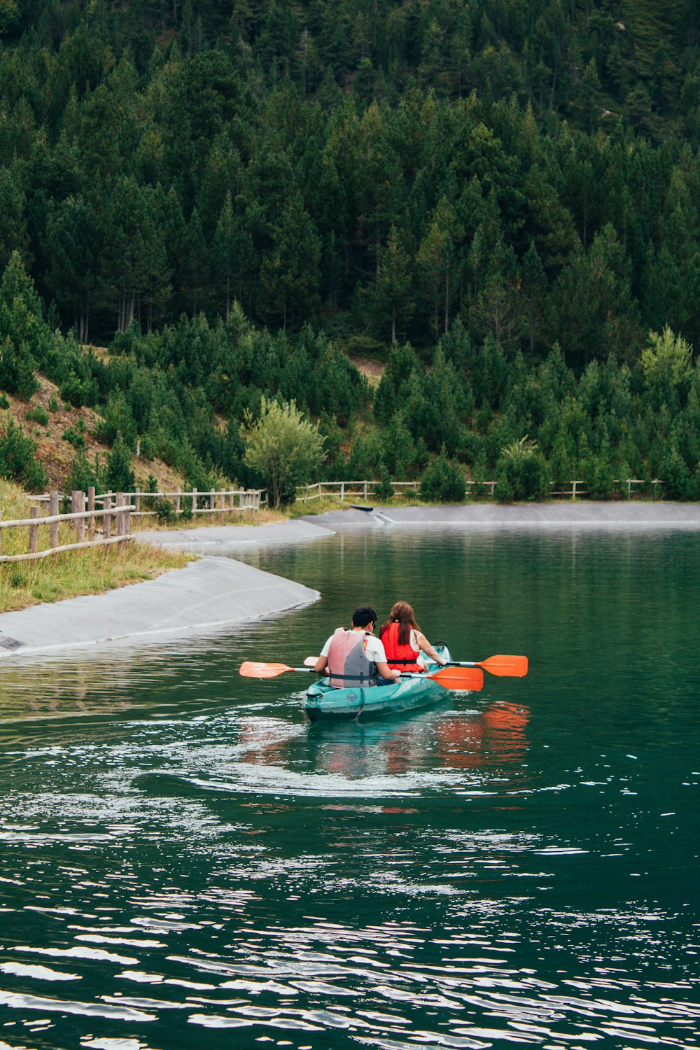a couple people in a canoe on a lake