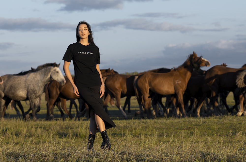 a man posing in front of a herd of horses