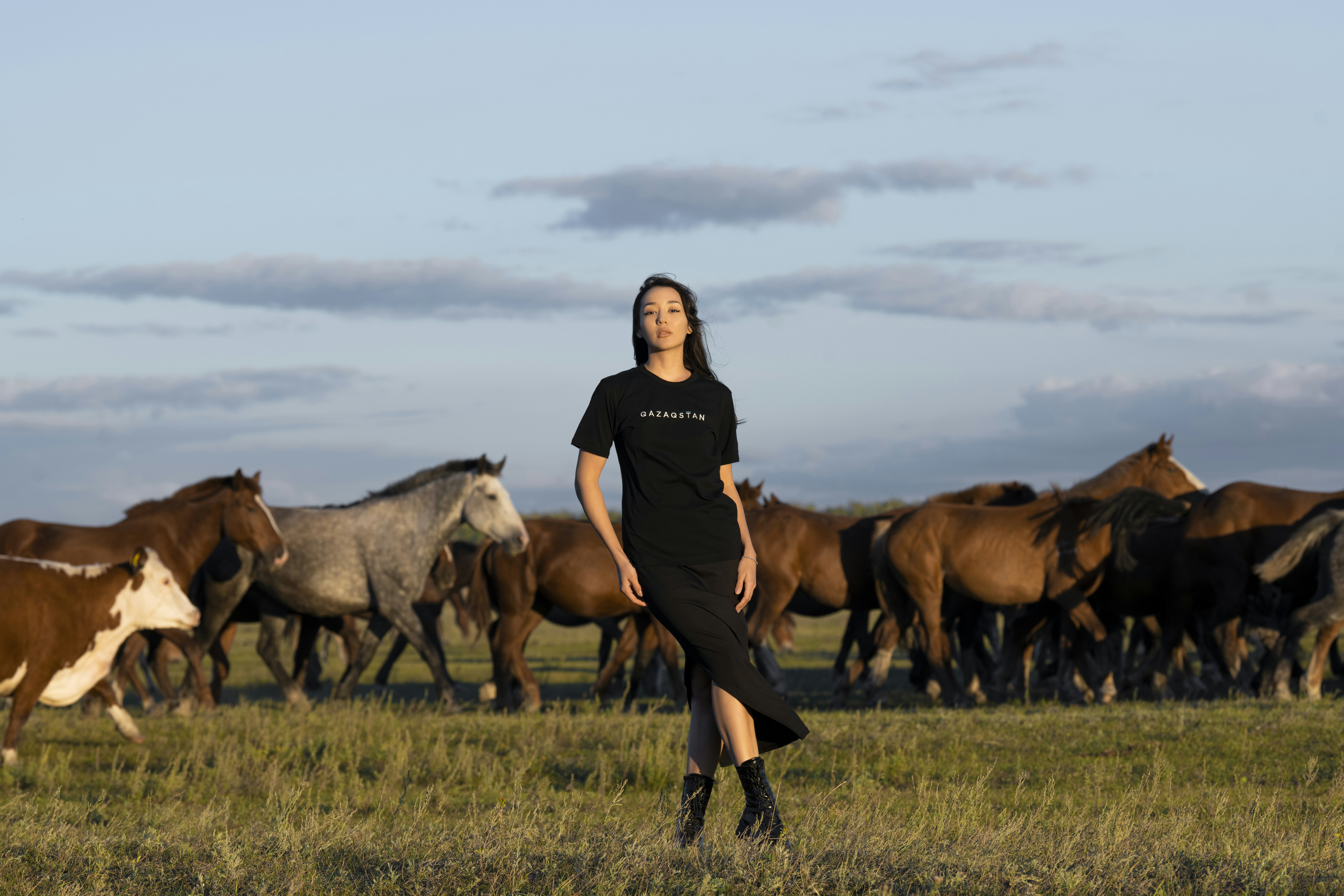 a person standing in front of a herd of horses