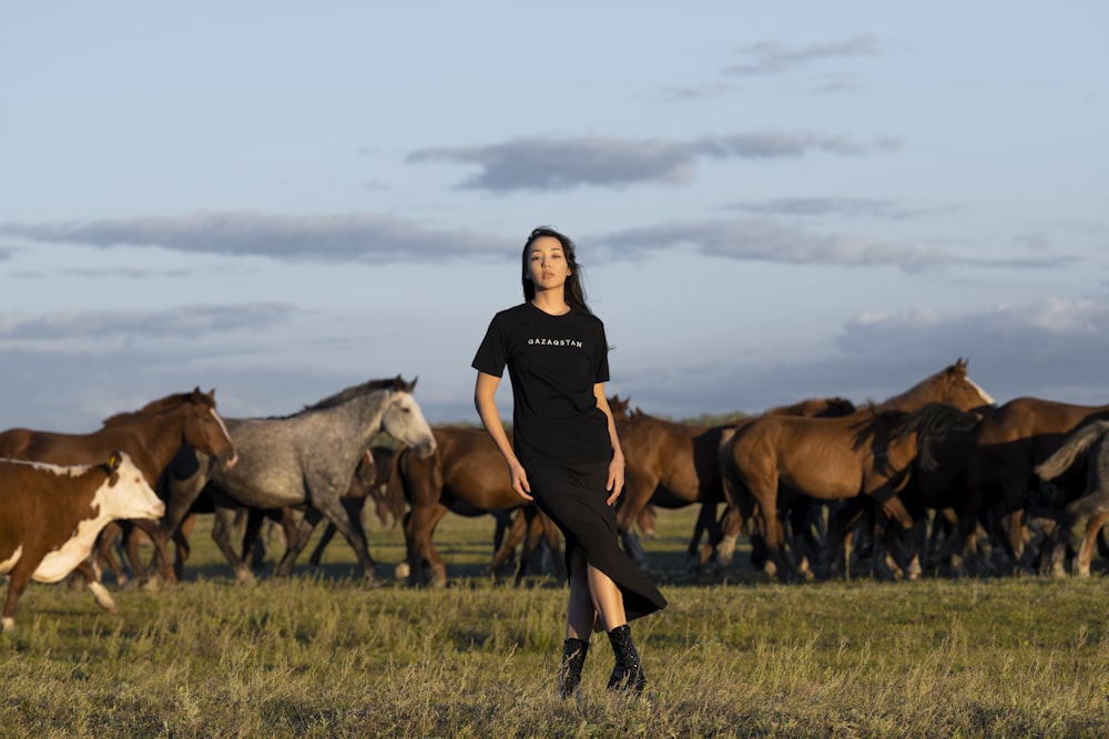 uma pessoa em pé na frente de uma manada de cavalos