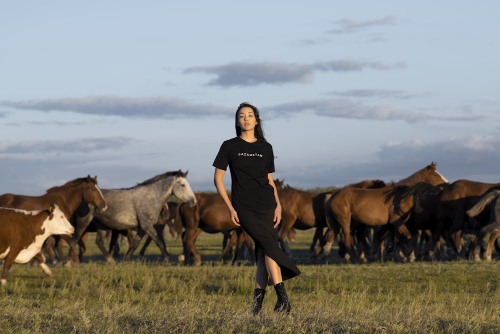 a person standing in front of a herd of horses