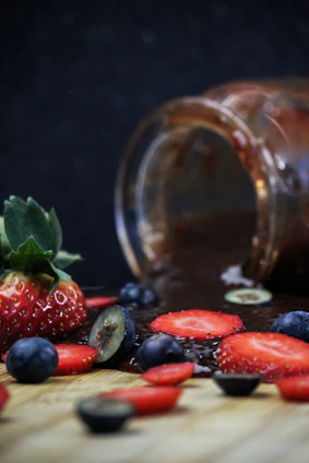 Bright and colorful berries pulps in glass jars with fresh berries scattered