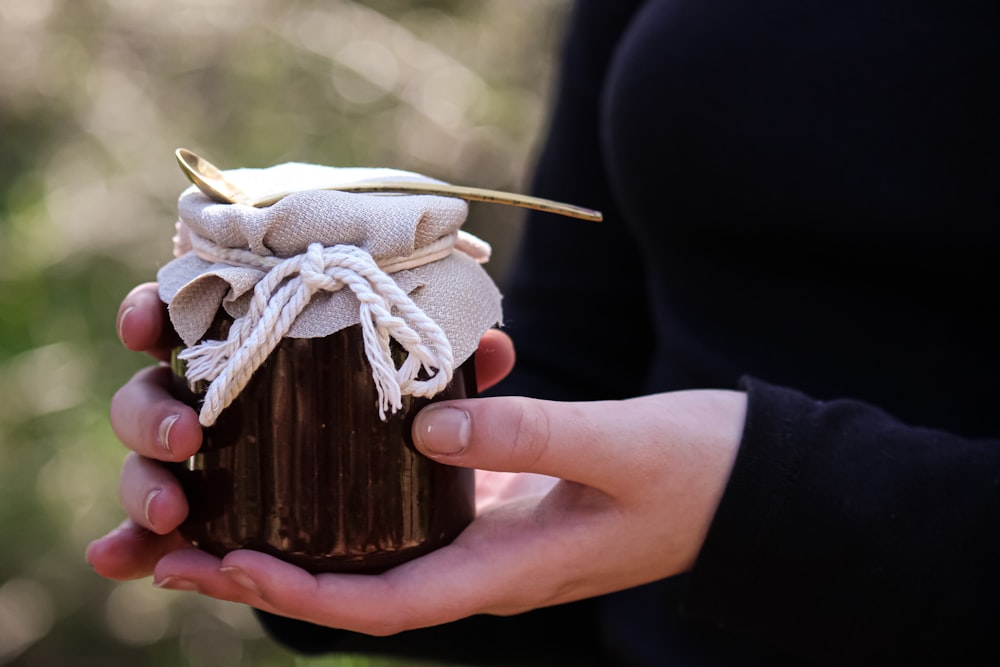 a person holding a cupcake with a straw