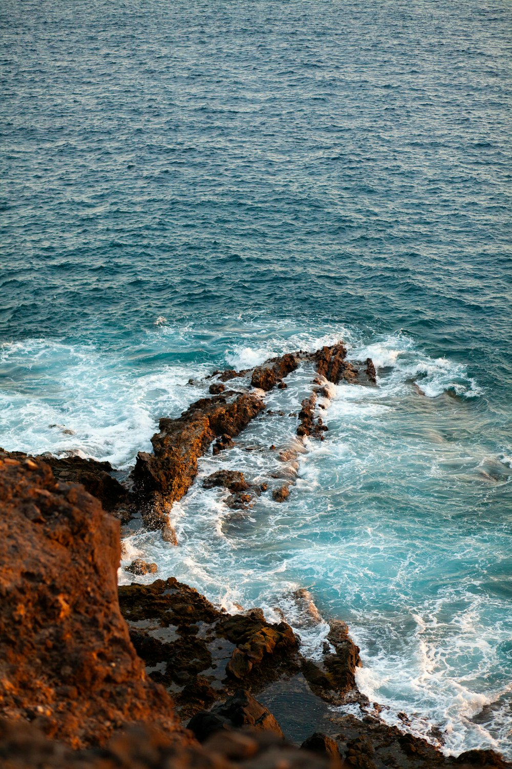 a rocky beach with waves crashing against it