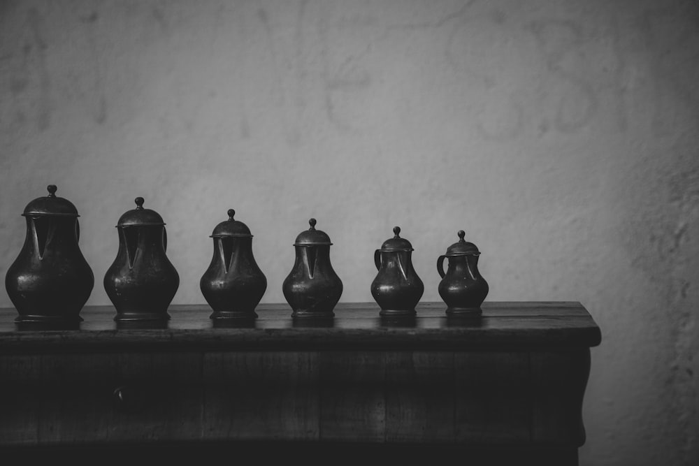 a group of vases sit on a shelf