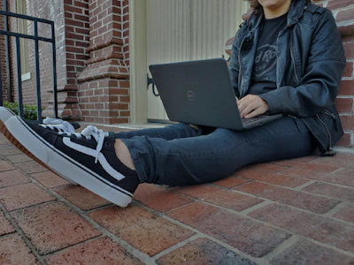 a person sitting on the ground with a laptop