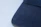 Close-up of a navy daxwear shirt sleeve with fine stitching detail on a wooden table.