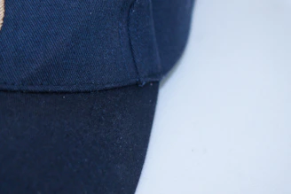 Close-up of a folded black embroidered cap with a minimalist urban background