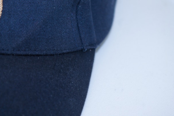 Close-up of a stylish cap with the ment logo embroidered on the front