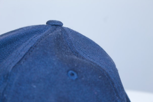 Close-up of a beige baseball cap showing fine stitching and soft fabric texture.