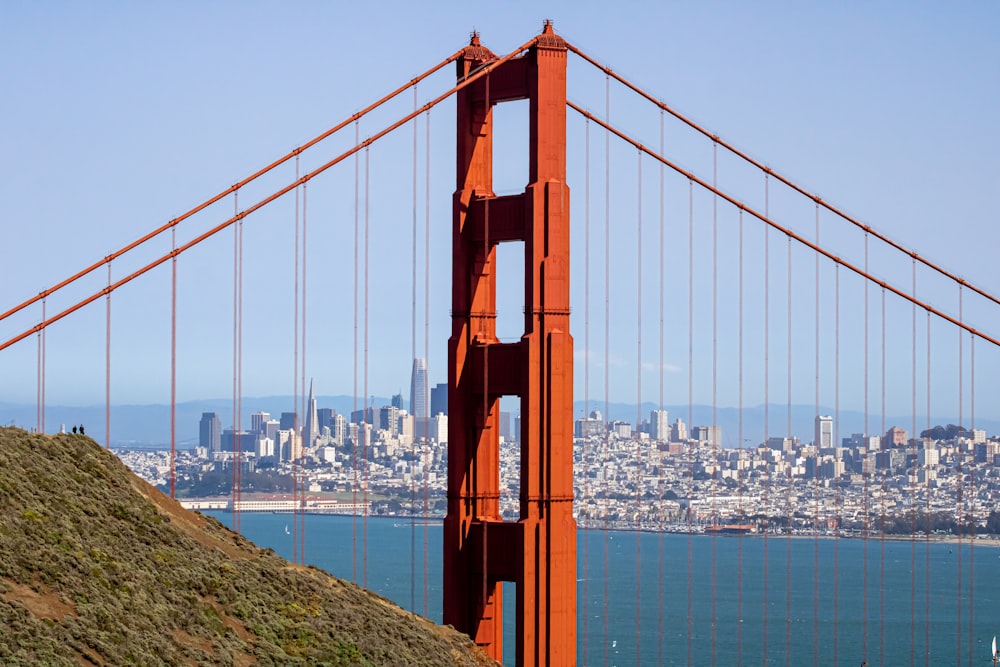 a large red bridge over water with Golden Gate Bridge in the background