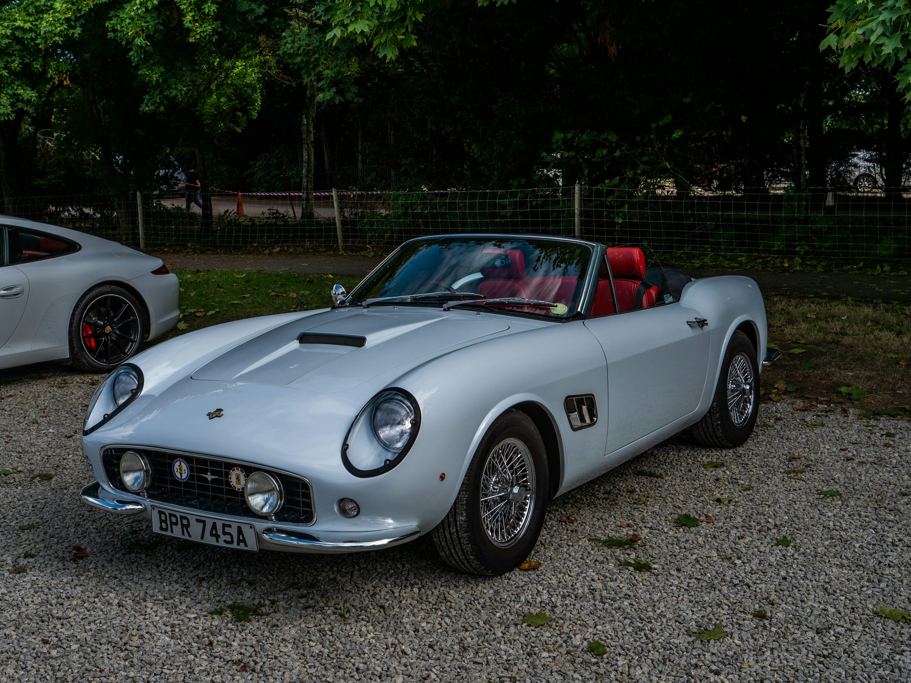 a white car parked on gravel