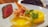 A gourmet dish featuring a piece of seared steak cooked to medium rare on the left side of the plate, accompanied by a lobster tail in the middle. On the right, there is a small bowl of melted butter and a lemon wedge, garnished with a sprig of parsley.