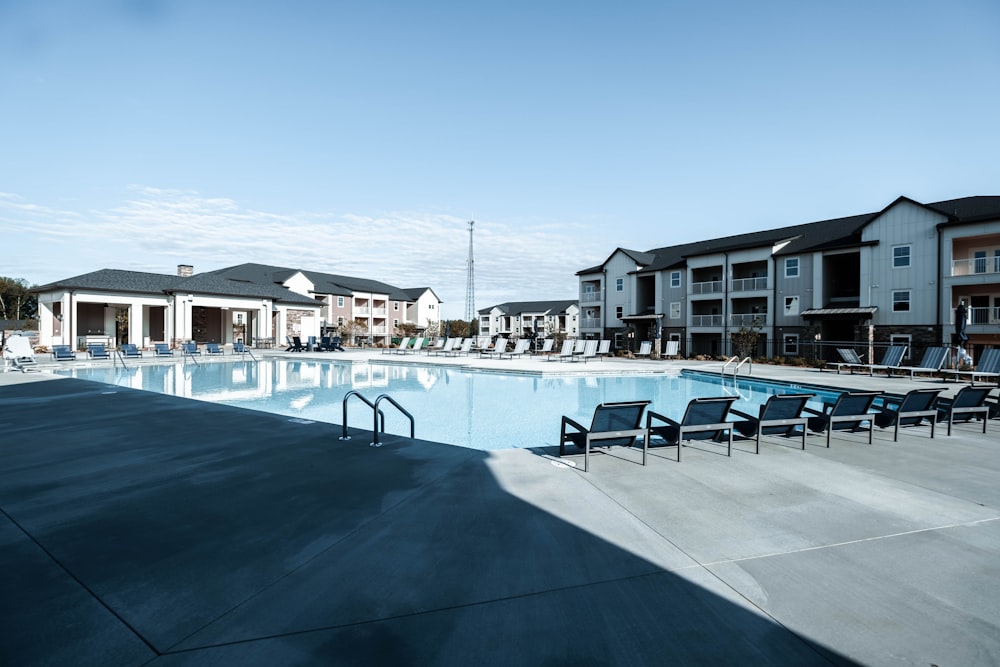 a swimming pool with chairs and tables