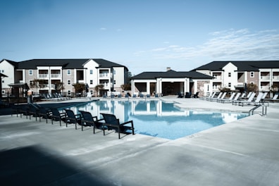 a swimming pool with chairs around it