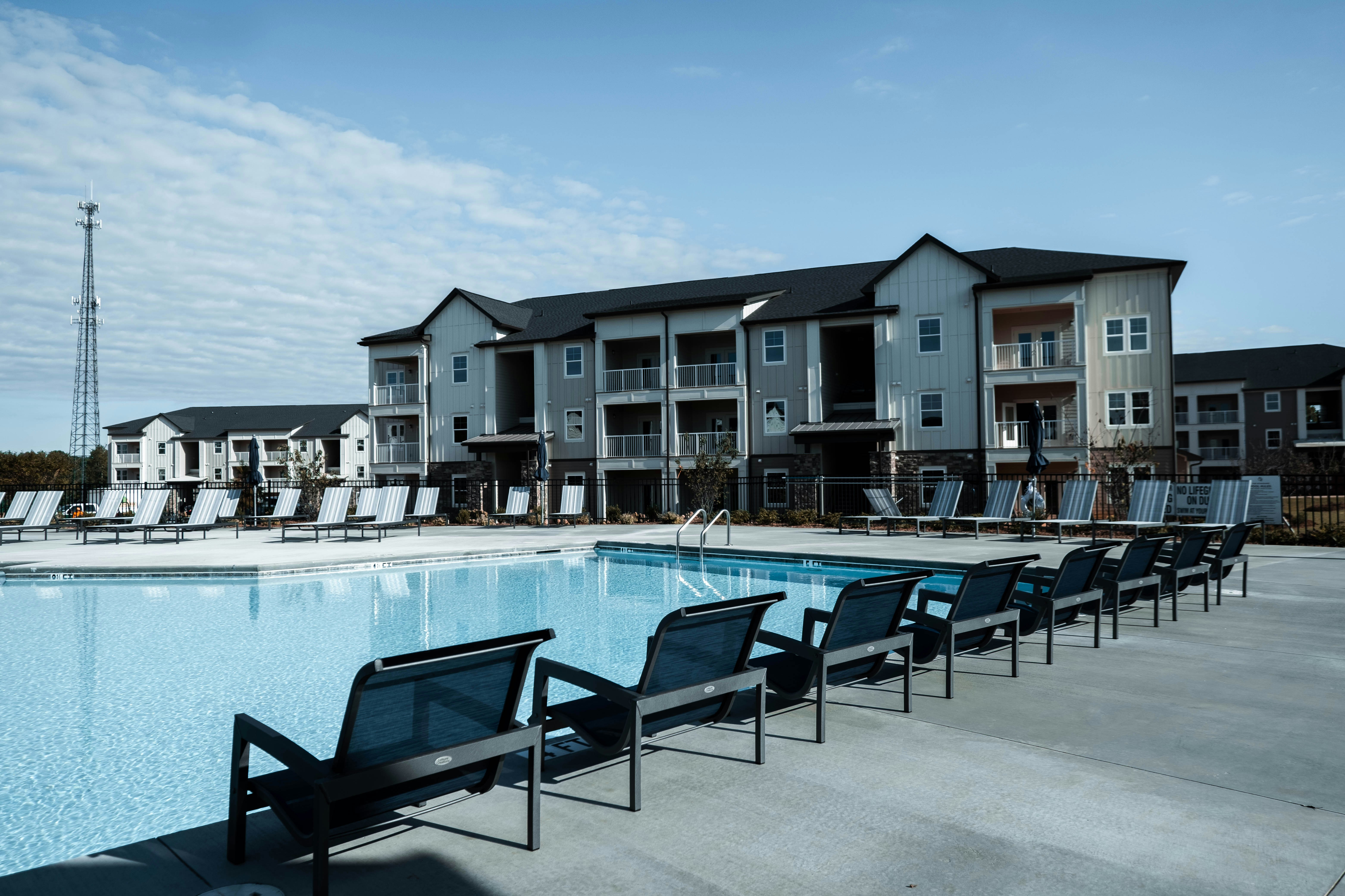 a pool with chairs and tables by it