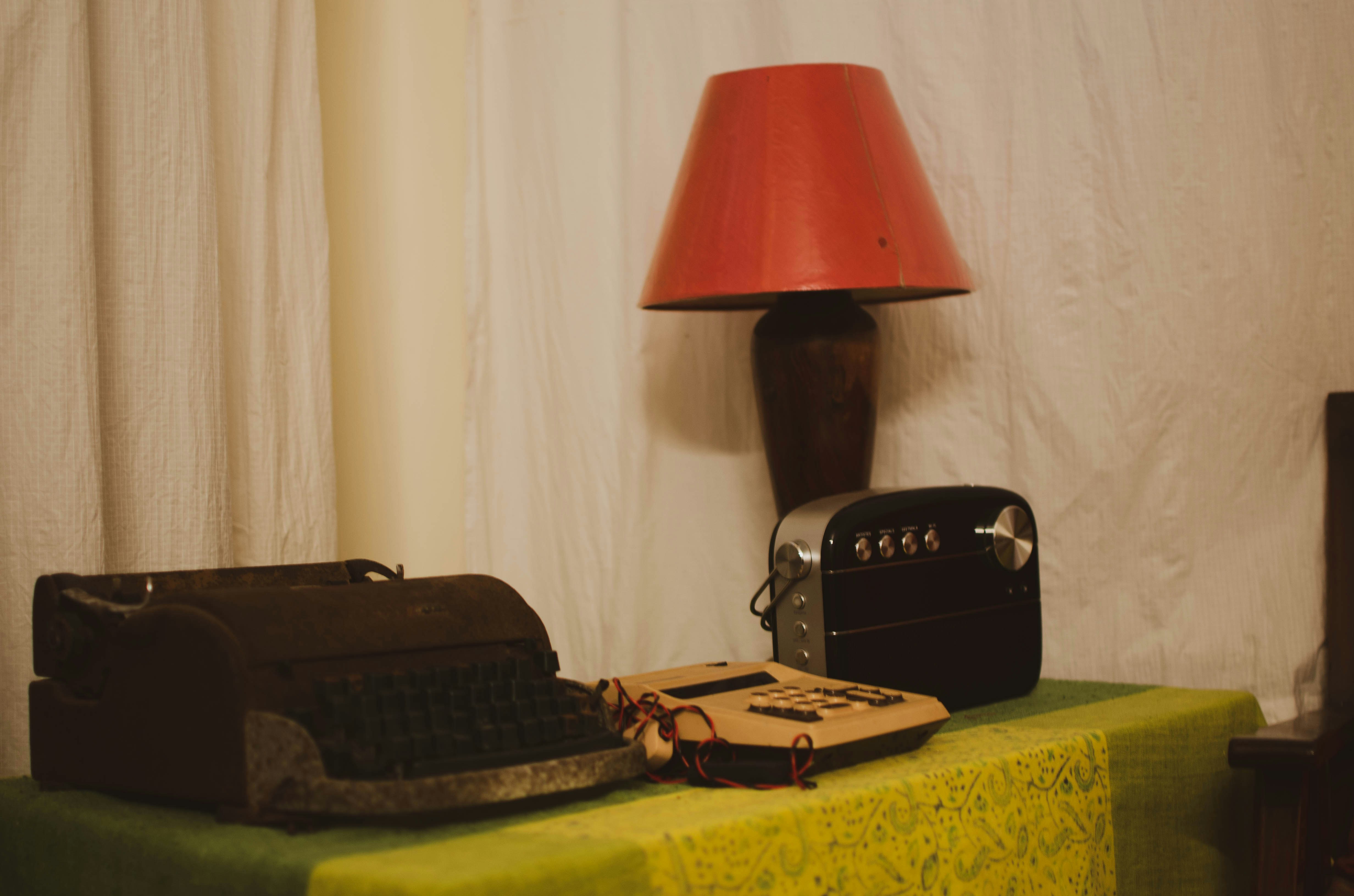 une lampe noire et rouge sur une table avec une valise noire