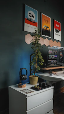 A cozy workspace with sketches and diecast model cars arranged beside elegant wooden display frames.