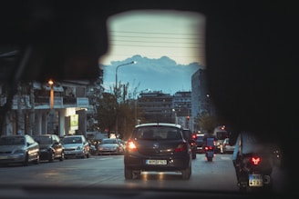 A daytime city view of Leicester with a driving school car navigating through traffic
