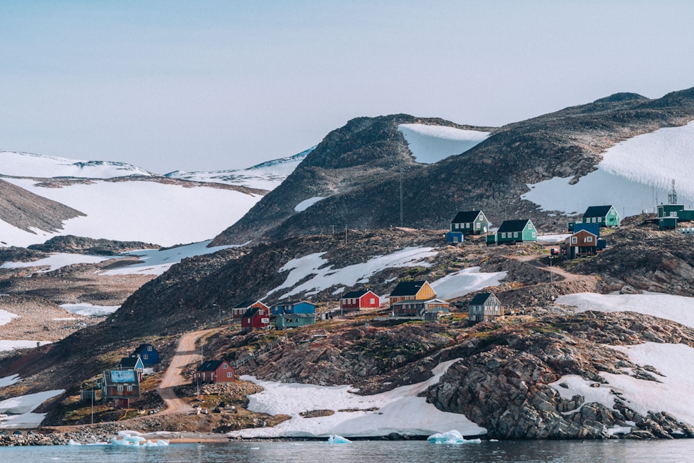 um grupo de casas em uma colina com a estação McMurdo ao fundo