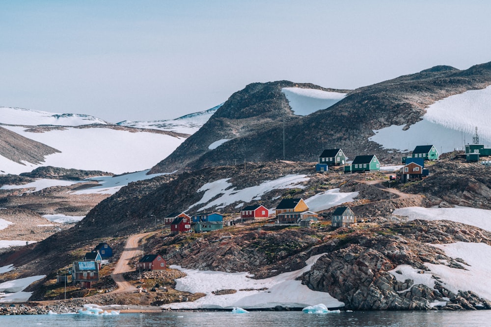 un grupo de casas en una colina con la estación McMurdo al fondo
