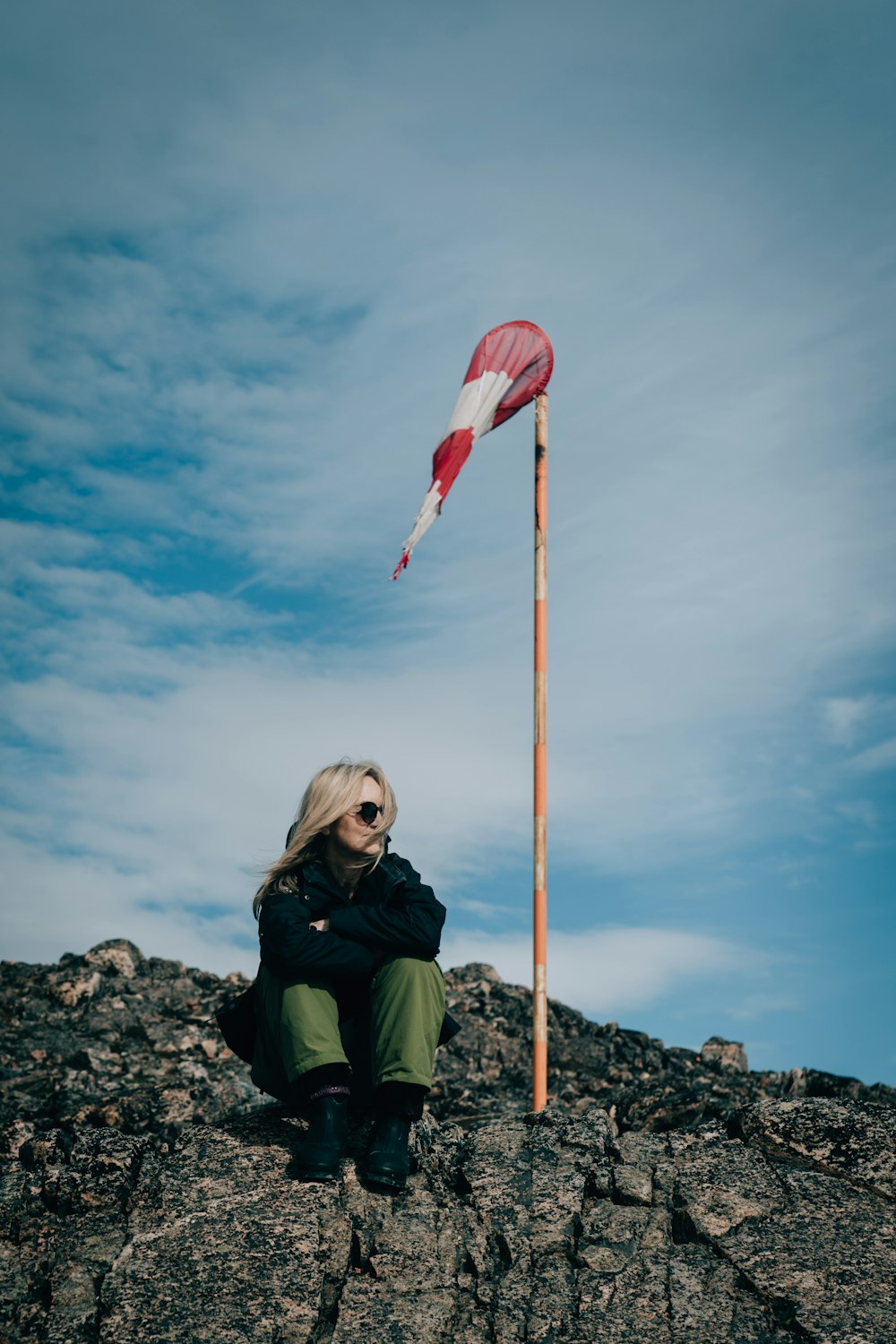 a man sitting on a rock with a flag on top of his