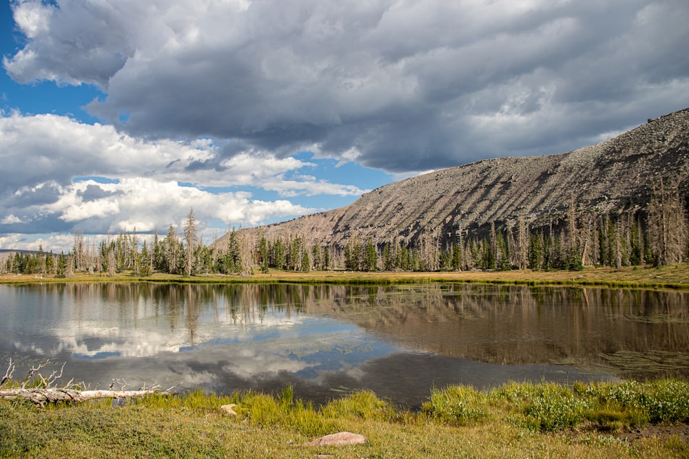 a lake with trees and mountains in the background