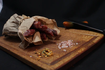 A well-organized barbecue setup with knives, spices, and a wooden board.