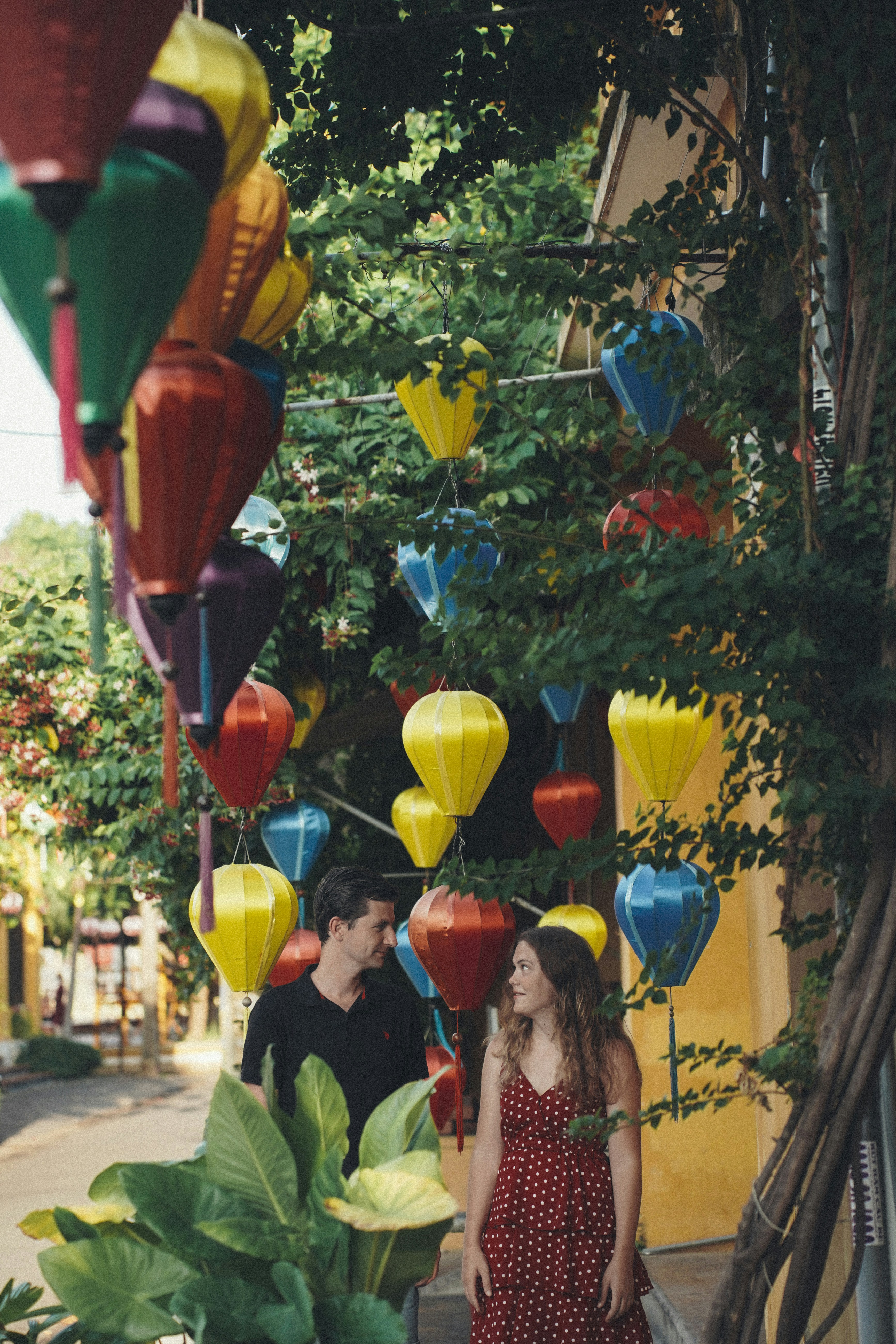 Ein Mann und eine Frau stehen unter einem Baum mit Laternen davon