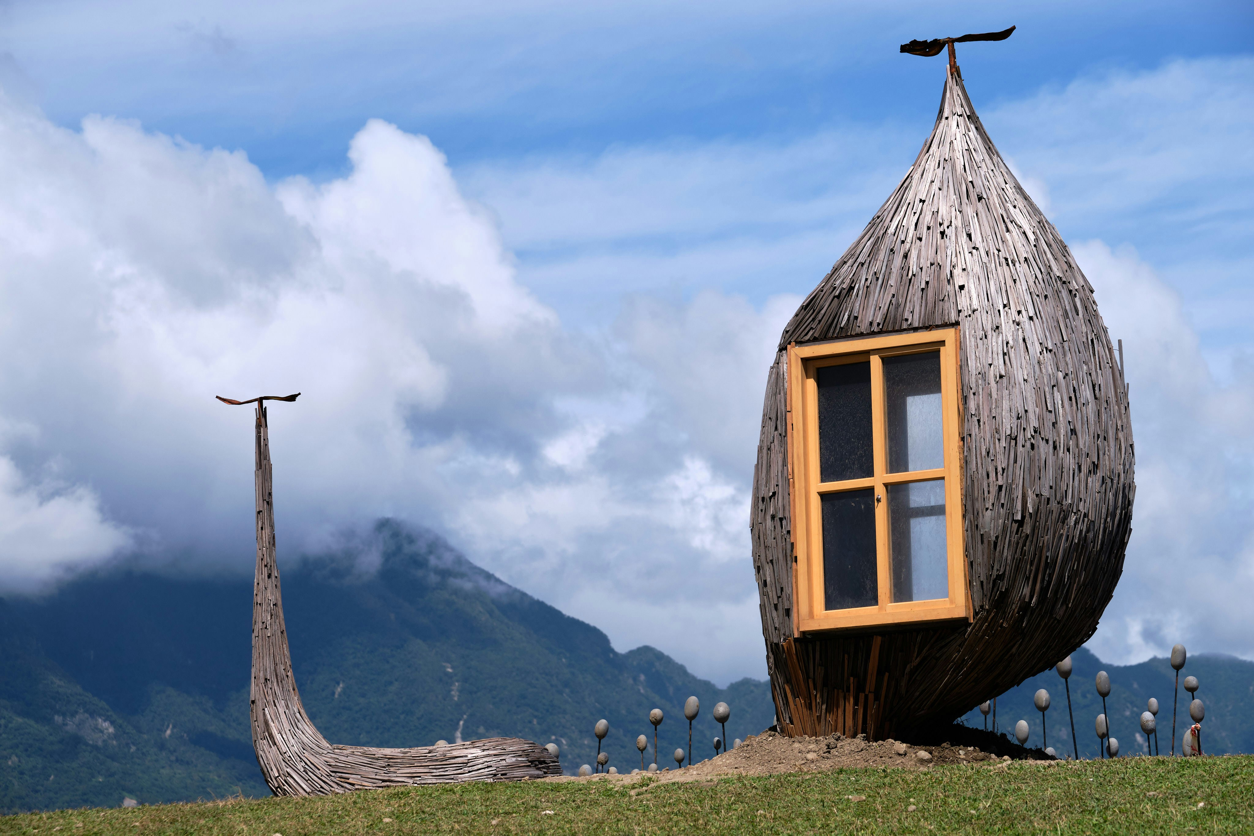 a wooden house with a cross on top of it