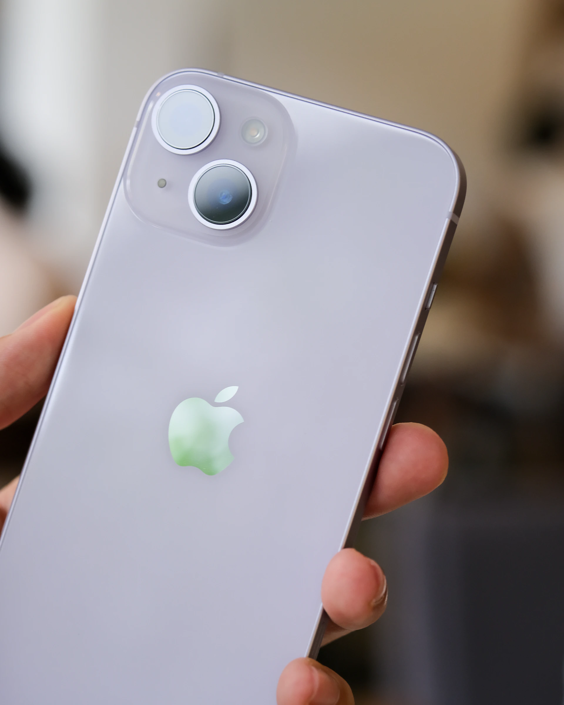 a hand holding a white cell phone