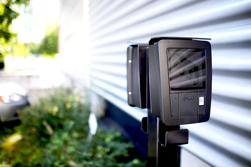 Black and white photo of a technician setting up a POC radio communication device in an industrial environment.