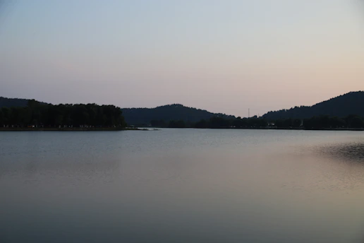 A serene sunrise over a quiet mountain lake, reflecting soft pastel colors.