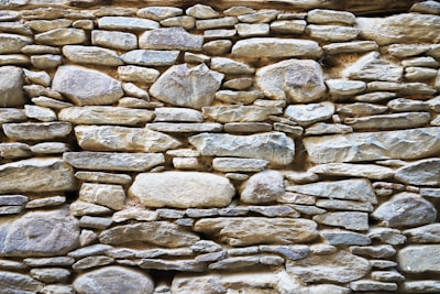 Rustic stone wall with varied shapes and earthy colors, highlighting natural texture.