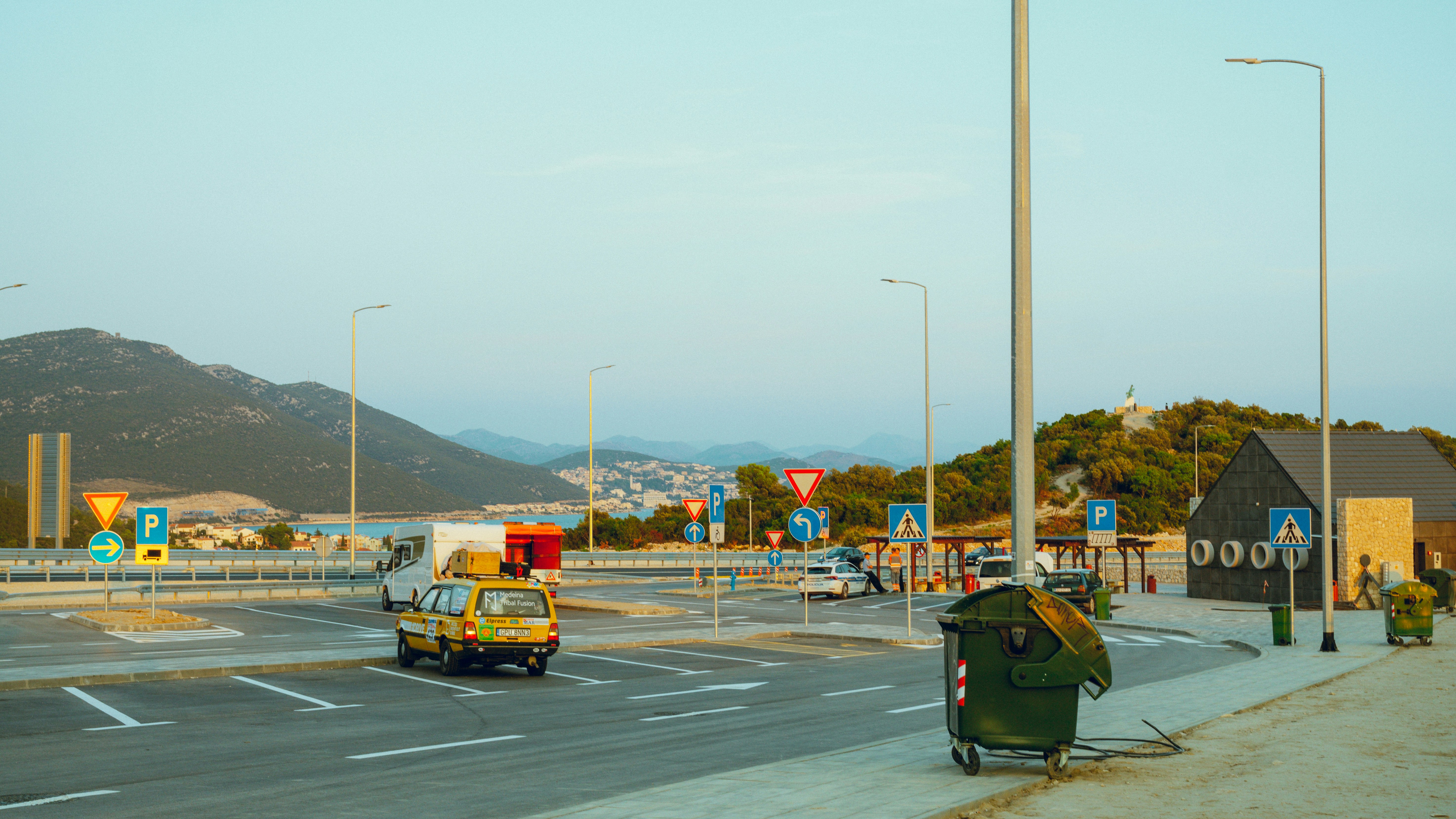 a yellow car driving down a road