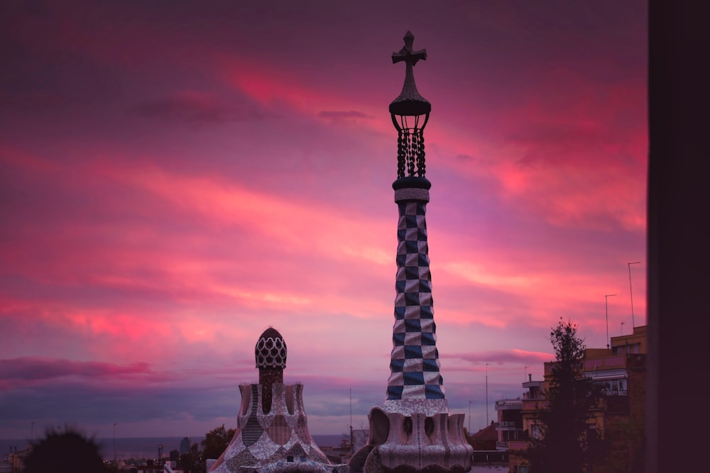 a tall tower with a statue in front of it