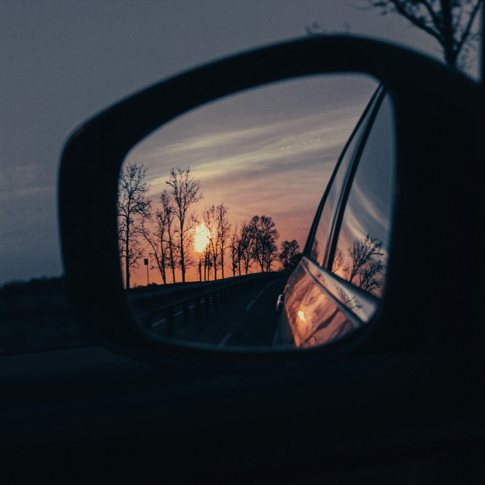 a side view mirror showing a sunset