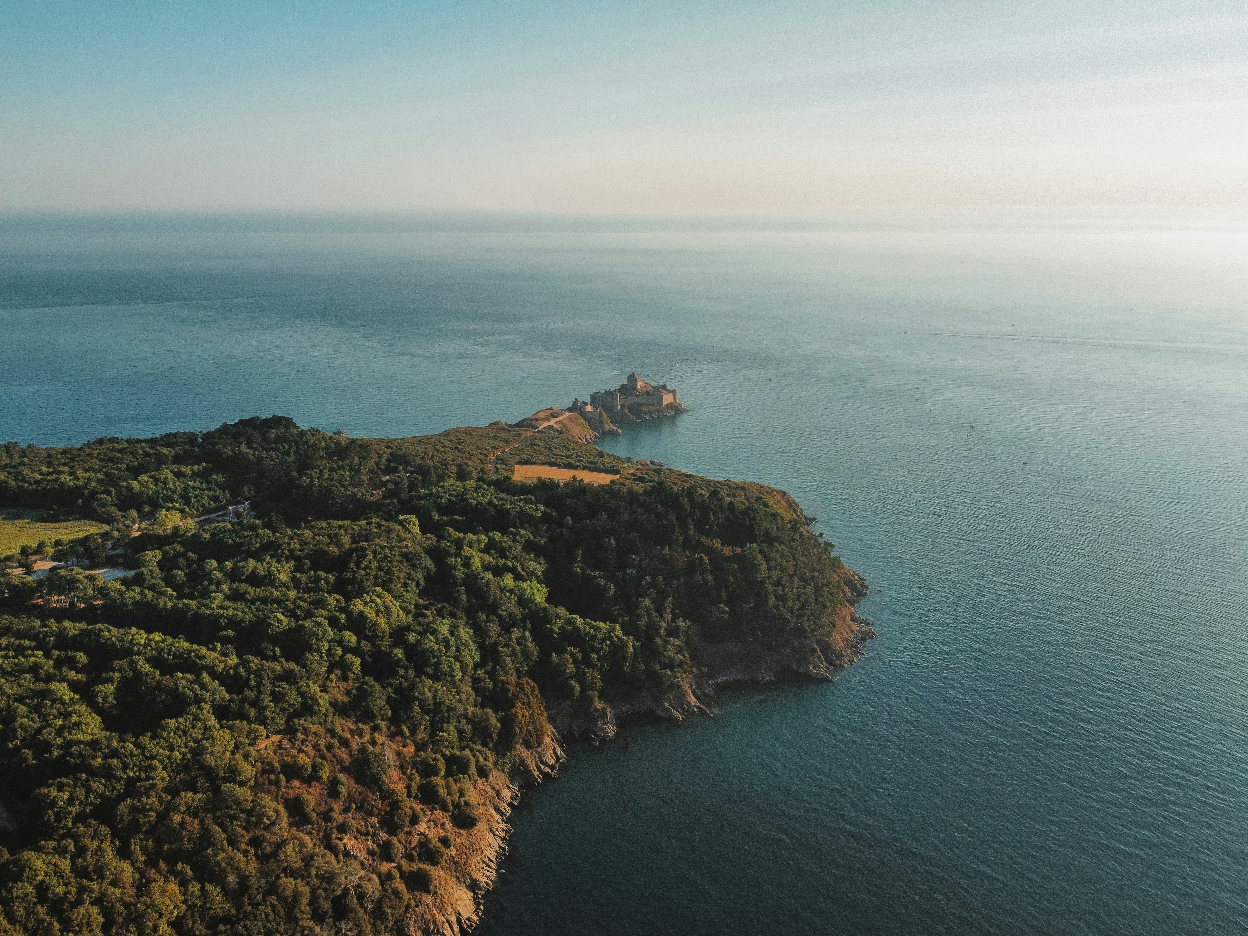 Una isla rocosa con un barco foto – Imagen de Gris gratuita en Unsplash