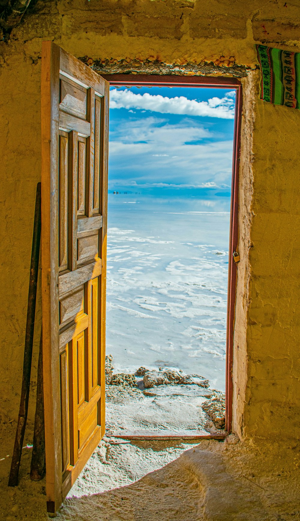 a door with a view of the ocean and a beach